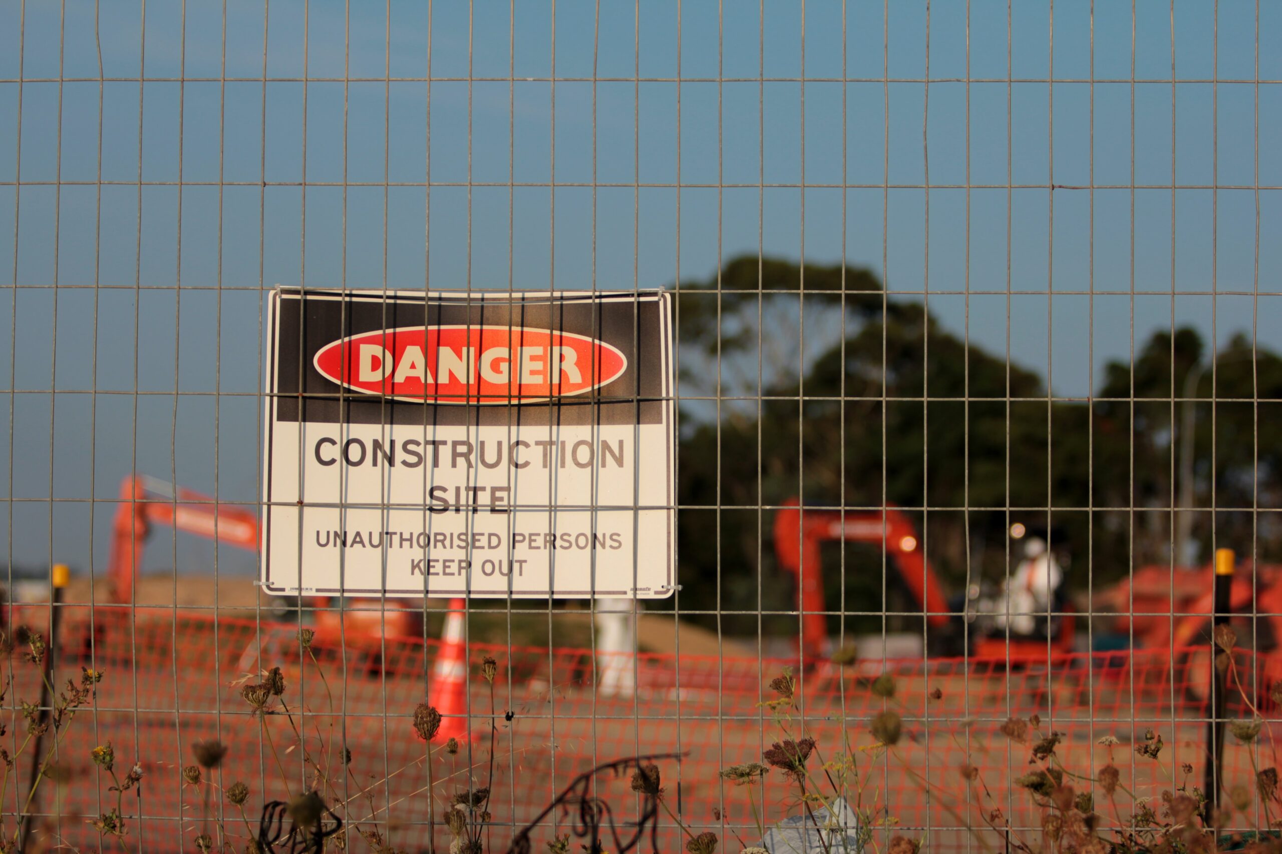 picture of a construction sign behind a fence